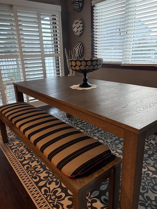 Bench cushion made with slightly rounded corners made in waterfall construction with Sunbrella Berenson Tuxedo fabric with Sunbrella Heritage Garnet trim with 4 ties at all corners at 2″ thickness.