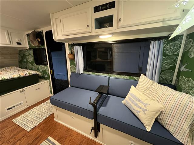 2 loveseat cushions set in boxed construction with Sunbrella Sapphire Blue fabric and double welt Forest Green trimming, polyurethane foam with fiber batting, ties at sides of back cushions only