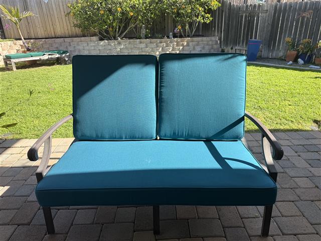 Custom loveseat cushion set in boxed construction with Sunbrella Spectrum Peacock fabric and trimming, polyurethane foam with fiber batting, ties at seat cushion's rear corners and sides of back cushion